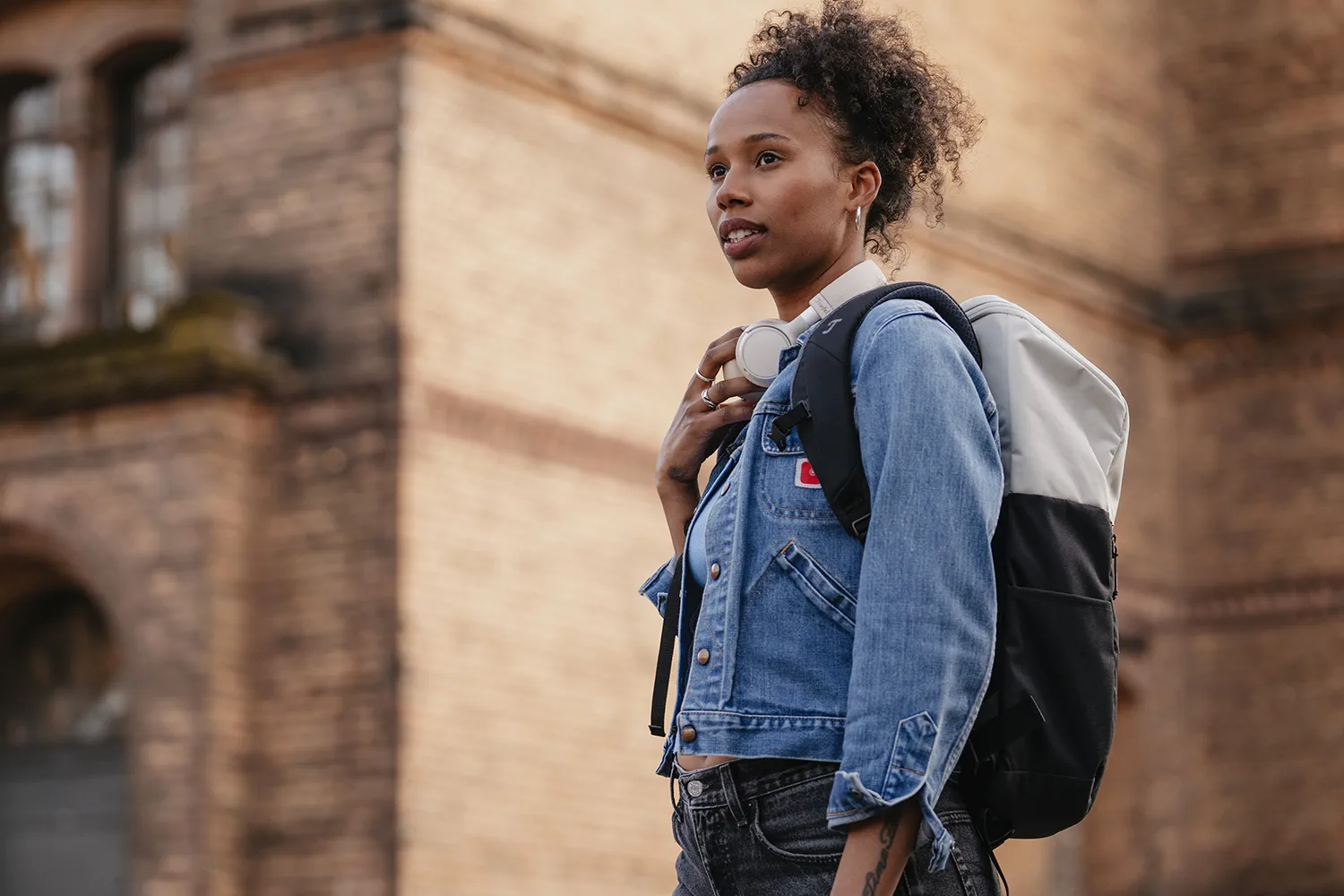 denim jacket, backpack, headphones, curly hair, street style