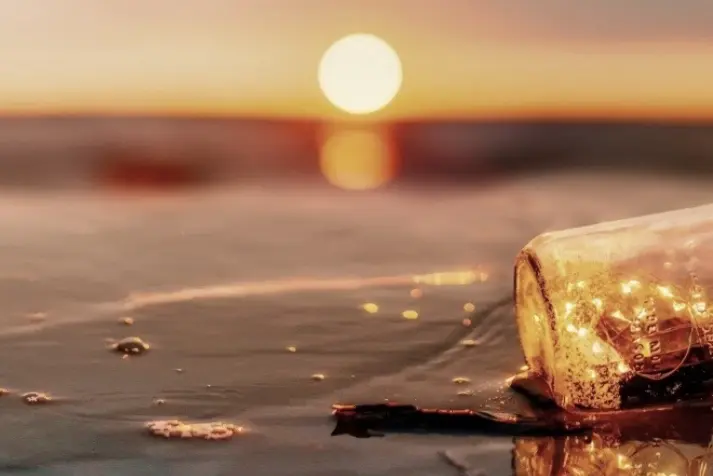SDG_7_saubere_Energie glass bottle, sunset, beach, foam, drifted bottle